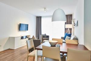 ein Esszimmer und ein Wohnzimmer mit Tisch und Stühlen in der Unterkunft Deichhäuser Anna Küste Deichhäuser Anna Küste 4-20 in Bensersiel