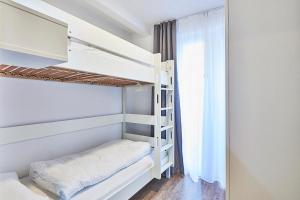 ein weißes Etagenbett in einem Zimmer mit Fenster in der Unterkunft Deichhäuser Anna Küste Deichhäuser Anna Küste 4-20 in Bensersiel + 14 Fotos