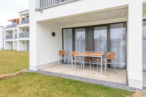 einen Tisch und Stühle auf einer Terrasse außerhalb eines Gebäudes in der Unterkunft Deichhäuser Anna Küste Deichhäuser Anna Küste 4-10 in Bensersiel