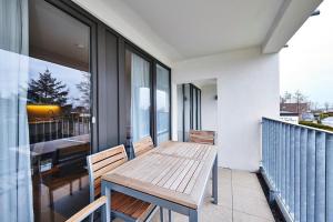 einen Holztisch auf dem Balkon eines Hauses in der Unterkunft Deichhäuser Anna Küste Deichhäuser Anna Küste 4-23 in Bensersiel