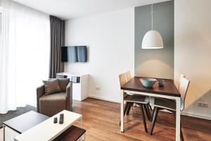 ein Wohnzimmer mit einem Tisch, einem Stuhl und einem Sofa in der Unterkunft Deichhäuser Anna Küste Deichhäuser Anna Küste 4-31 in Bensersiel