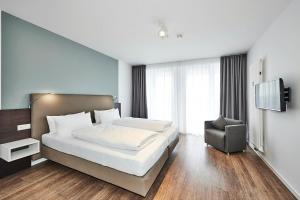 ein Hotelzimmer mit einem Bett und einem Stuhl in der Unterkunft Deichhäuser Anna Küste Deichhäuser Anna Küste 4-31 in Bensersiel + 14 Fotos