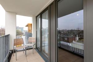 ein Balkon mit zwei Stühlen und Blick auf eine Stadt in der Unterkunft Deichhäuser Anna Küste Deichhäuser Anna Küste 4-31 in Bensersiel