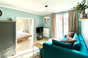 a living room with a blue couch and a bedroom at Dünenschloss Dünenschloss 2-16 in Kühlungsborn