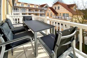 a patio table and chairs on a balcony with a building at Dünenschloss Dünenschloss 2-16 in Kühlungsborn