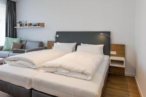 una camera da letto con due letti e un divano di Deichhäuser Anna Küste Deichhäuser Anna Küste 8-22 a Bensersiel Altre 9 foto