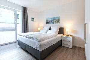 - une chambre avec un grand lit et une fenêtre dans l'établissement Aparthotel Ostseeallee Aparthotel Ostseeallee 5-40, à Boltenhagen