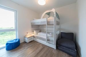 シリヒにあるNordsee Ferienpark Nordsee Ferienpark 47-3-nの二段ベッドと椅子のある寝室