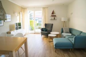 ein Wohnzimmer mit einer Couch und Stühlen und einem Tisch in der Unterkunft Apartment-Residenz Ostseestrand Apartment-Residenz Ostseestrand 11 in Kühlungsborn