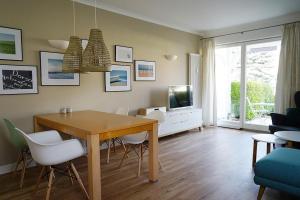 ein Wohnzimmer mit Tisch und Stühlen und einem Fernseher in der Unterkunft Apartment-Residenz Ostseestrand Apartment-Residenz Ostseestrand 11 in Kühlungsborn