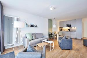 un salon avec un canapé, des chaises et une table dans l'établissement Deichhäuser Anna Küste Deichhäuser Anna Küste 4-30, à Bensersiel