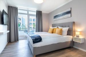 ein Schlafzimmer mit großem Bett und Balkon in der Unterkunft Godewindpark Travemünde Godewindpark Travemünde 1-07 in Travemünde