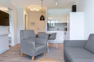 a living room with a couch and a table and chairs at Godewindpark Travemünde Godewindpark Travemünde 1-12 in Travemünde