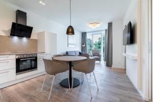 a kitchen and living room with a table and chairs at Godewindpark Travemünde Godewindpark Travemünde 1-12 in Travemünde