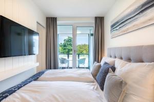 a bedroom with a bed with a flat screen tv at Godewindpark Travemünde Godewindpark Travemünde 1-12 in Travemünde