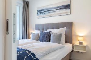 a bedroom with two beds and a window at Godewindpark Travemünde Godewindpark Travemünde 1-12 in Travemünde +7 photos