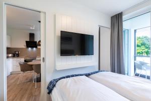 a bedroom with a bed with a tv on a wall at Godewindpark Travemünde Godewindpark Travemünde 1-12 in Travemünde