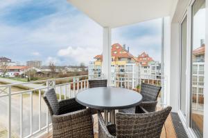 einen Balkon mit einem Tisch und Stühlen sowie Stadtblick in der Unterkunft Apartmentanlage Meerblickvilla Apartmentanlage Meerblickvilla 2-18 in Großenbrode