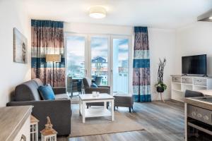 ein Wohnzimmer mit einer Couch und einem Tisch in der Unterkunft Apartmentanlage Meerblickvilla Apartmentanlage Meerblickvilla 2-18 in Großenbrode