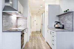 eine Küche mit weißen Schränken und einer Spüle in der Unterkunft Apartmentanlage Meerblickvilla Apartmentanlage Meerblickvilla 2-18 in Großenbrode + 8 Fotos