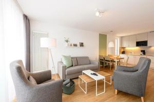 ein Wohnzimmer mit zwei Stühlen und einer Couch und einem Tisch in der Unterkunft Deichhäuser Anna Küste Deichhäuser Anna Küste 1-30 in Bensersiel