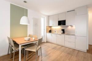 eine Küche und ein Esszimmer mit Tisch und Stühlen in der Unterkunft Deichhäuser Anna Küste Deichhäuser Anna Küste 1-30 in Bensersiel