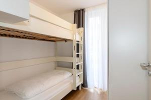 ein Schlafzimmer mit Etagenbett und Fenster in der Unterkunft Deichhäuser Anna Küste Deichhäuser Anna Küste 1-30 in Bensersiel + 11 Fotos