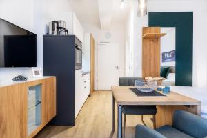 a living room with a table and a kitchen at Ferienapartments am Krusespeicher Ferienapartments am Krusespeicher 1-07 in Wismar