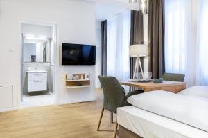 a hotel room with a bed and a desk and a television at Ferienapartments am Krusespeicher Ferienapartments am Krusespeicher 0-02 in Wismar