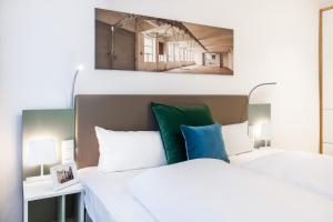 a bedroom with a bed with white and blue pillows at Ferienapartments am Krusespeicher Ferienapartments am Krusespeicher 0-02 in Wismar