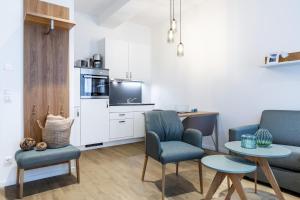 ein Wohnzimmer mit Sofa, Stühlen und einem Tisch in der Unterkunft Ferienapartments am Krusespeicher Ferienapartments am Krusespeicher 2-18 in Wismar