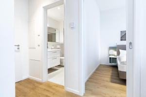a white bathroom with a sink and a mirror at Ferienapartments am Krusespeicher Ferienapartments am Krusespeicher 2-19 in Wismar +14 photos