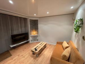 a living room with a couch and a fireplace at Casa Jaubertie - Appartement cosy et chaleureux refait à neuf - HYPER CENTRE BRIVE in Brive-la-Gaillarde