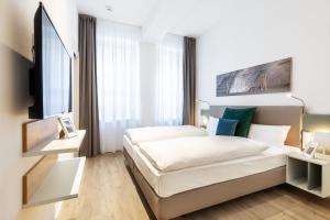 a bedroom with a bed and a flat screen tv at Ferienapartments am Krusespeicher Ferienapartments am Krusespeicher 2-20 in Wismar