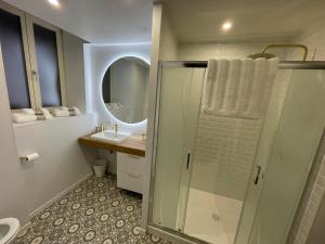 a bathroom with a shower and a sink and a mirror at Casa Jaubertie - Appartement cosy et chaleureux refait à neuf - HYPER CENTRE BRIVE in Brive-la-Gaillarde