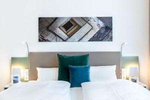 a bedroom with two white beds and a painting on the wall at Ferienapartments am Krusespeicher Ferienapartments am Krusespeicher 3-33 in Wismar