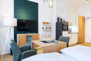 a living room with a table and chairs and a television at Ferienapartments am Krusespeicher Ferienapartments am Krusespeicher 3-33 in Wismar