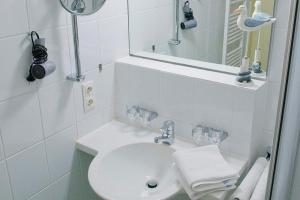 a white bathroom with a sink and a mirror at Seehof Seehof 23 in Bansin