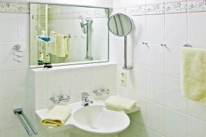 La salle de bains blanche est pourvue d'un lavabo et d'un miroir. dans l'établissement Seehof Seehof 41, à Bansin