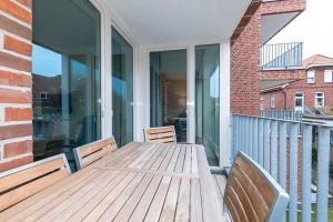 a wooden table with two chairs on a balcony at Apartmentvilla Anna See Apartmentvilla Anna See 2-07 in Langeoog