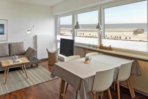 sala de estar con mesa de comedor y vistas a la playa en Haus Panorama Haus Panorama 12 en Wangerooge