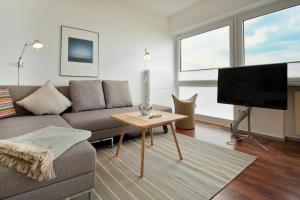 ein Wohnzimmer mit einem Sofa und einem Flachbild-TV in der Unterkunft Haus Panorama Haus Panorama 12 in Wangerooge