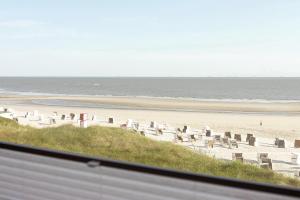 een strand met een stel stoelen en de oceaan bij Haus Panorama Haus Panorama 12 in Wangerooge