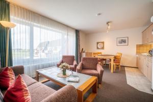 - un salon avec un canapé, des chaises et une table dans l'établissement Holiday Residenz Holiday Residenz A51, à Borkum