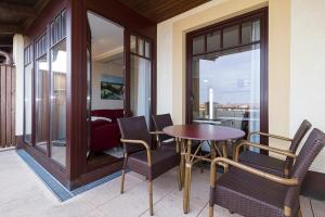 einen Balkon mit Tisch und Stühlen und ein Wohnzimmer in der Unterkunft Urlaubsräume am Meer Urlaubsräume am Meer 3-14 in Fulgen