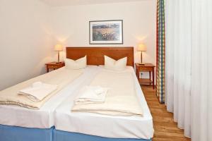 ein Schlafzimmer mit einem großen Bett mit weißer Bettwäsche und Kissen in der Unterkunft Strand-Park Strand-Park 304 in Heringsdorf