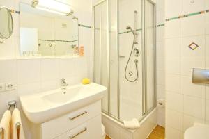 ein weißes Bad mit einem Waschbecken und einer Dusche in der Unterkunft Strand-Park Strand-Park 304 in Heringsdorf