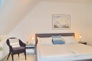 a bedroom with a bed and a chair at Residenz Seestern Residenz Seestern 2-31 in Boltenhagen +5 photos