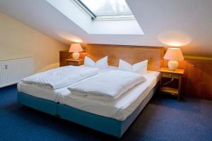 una camera da letto con un grande letto bianco con due lampade di Strand-Park Strand-Park 333 a Heringsdorf