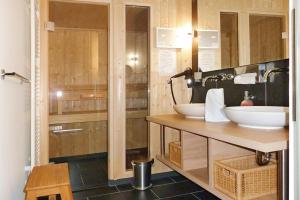 ein Badezimmer mit zwei Waschbecken auf einer Holztheke in der Unterkunft Resort Deichgraf Resort Deichgraf 27-06 in Wremen